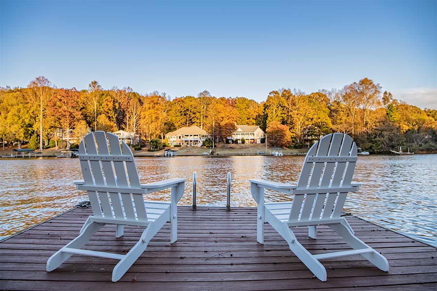 Private Client Insurance - Two Adirondack Chairs On Dock Overlooking Quiet Lake
